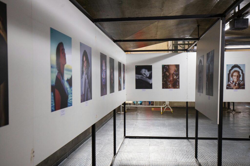 Foto de uma exposição de fotografia, uma parede branca com quadros expostos